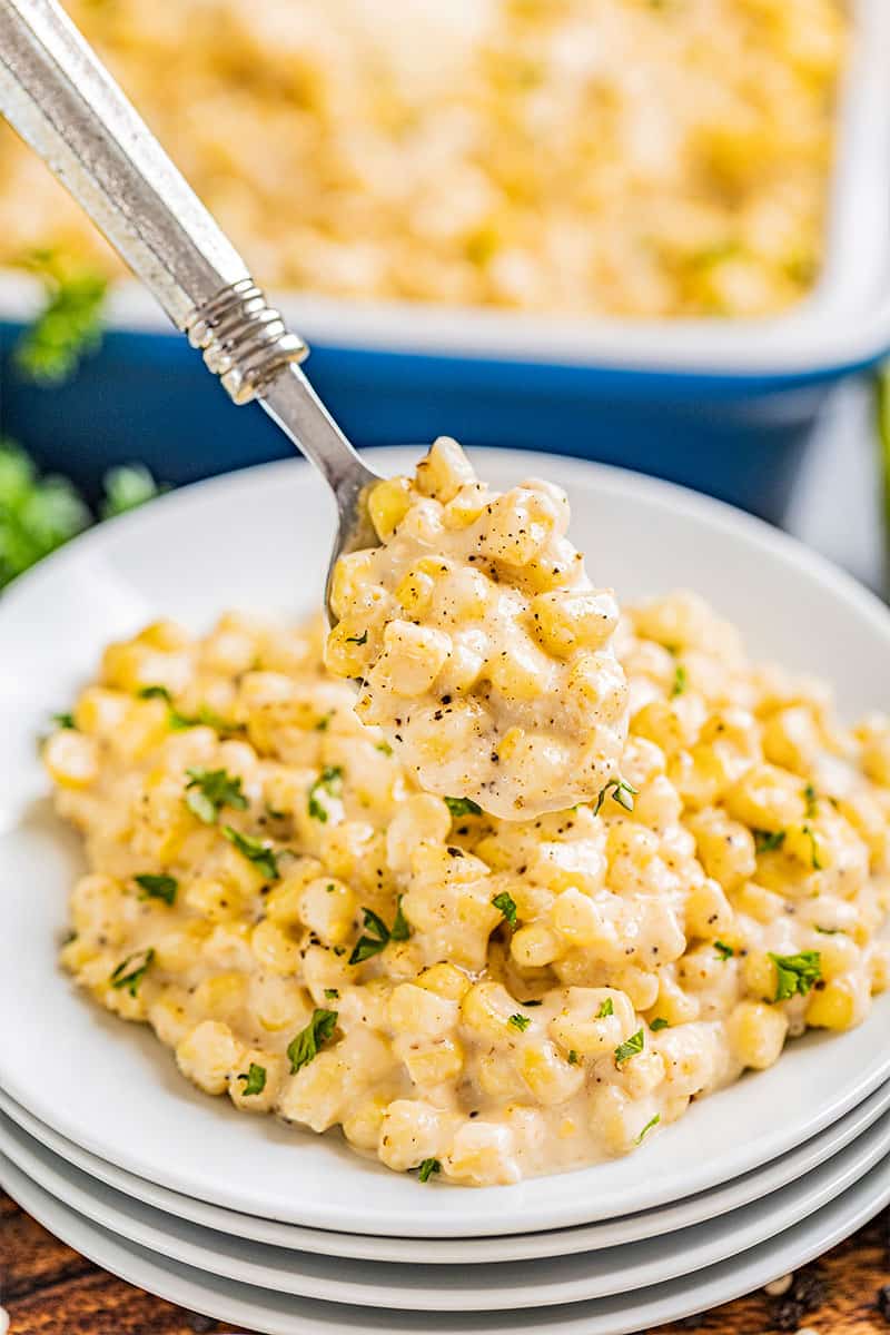 A spoon full of creamed corn.