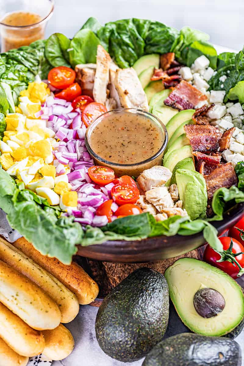 A large Cobb salad in a bowl, filled with toppings.