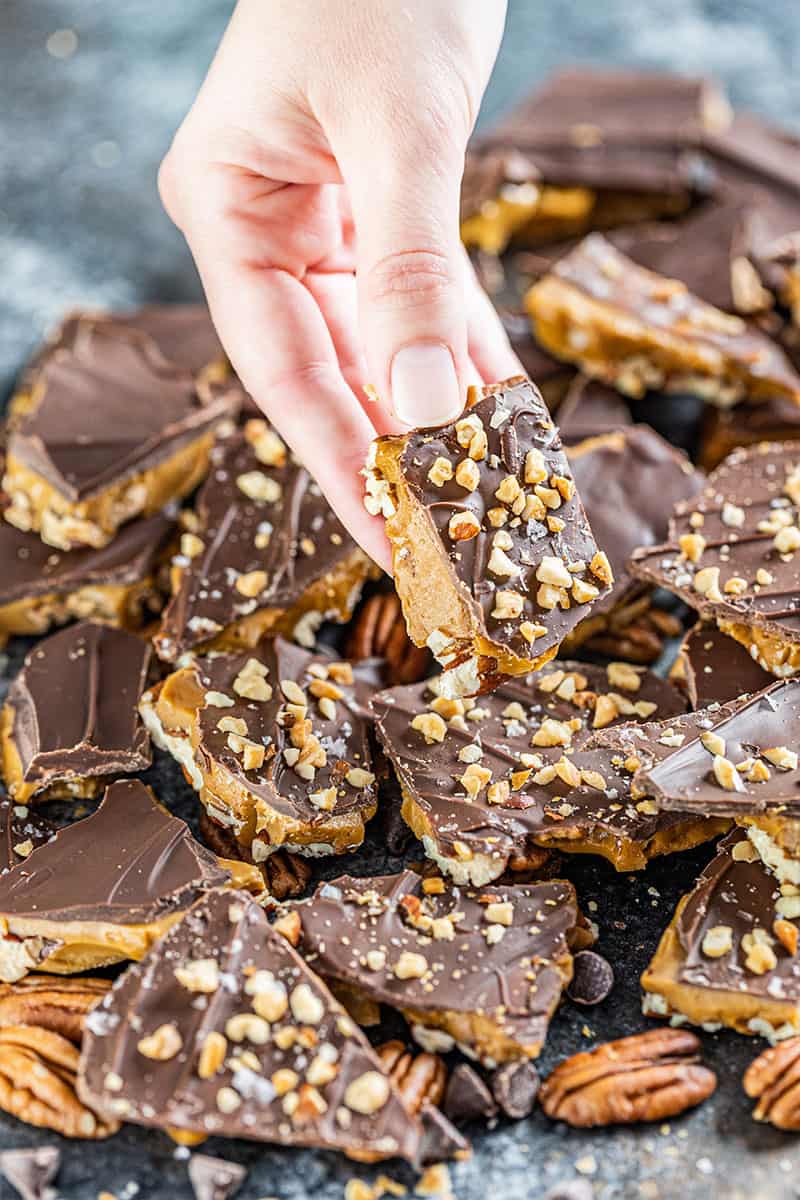 A hand holding a piece of toffee.