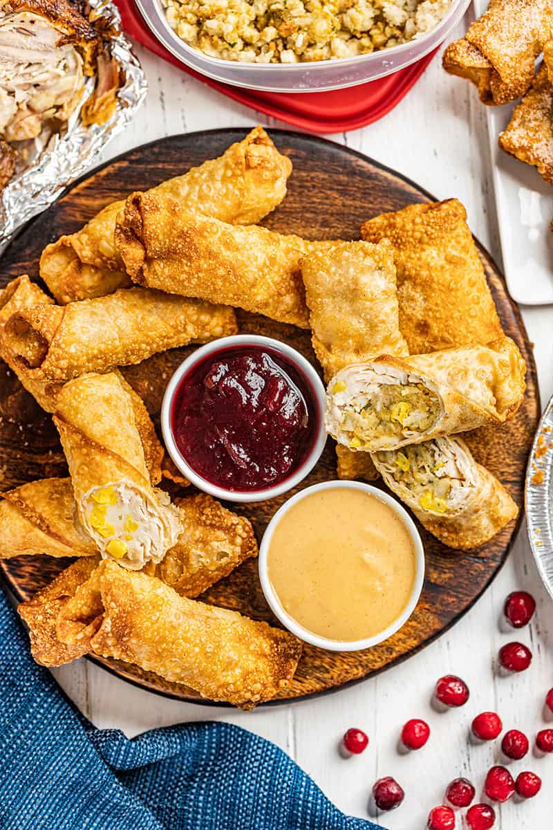 Overhead view of Thanksgiving leftover egg rolls with cranberry sauce and gravy.