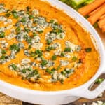 Buffalo chicken dip with green onions on top.