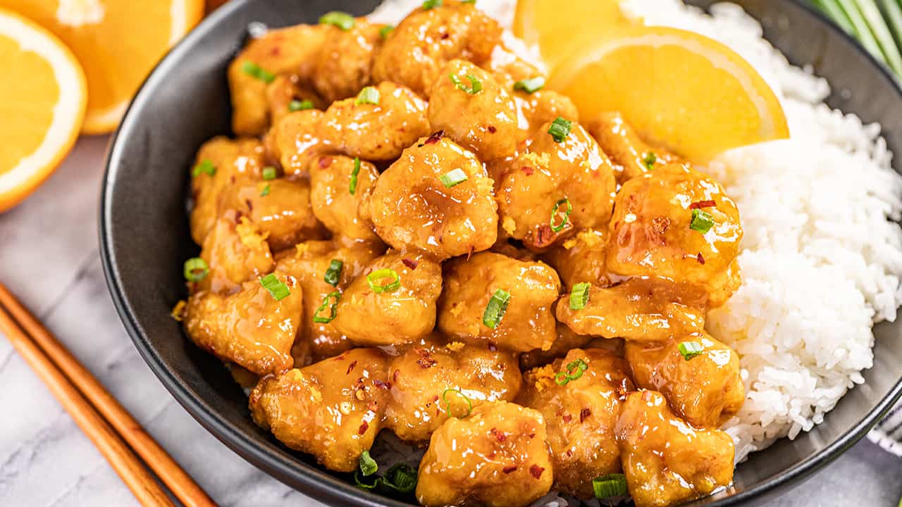 Close up view of orange chicken with white rice.