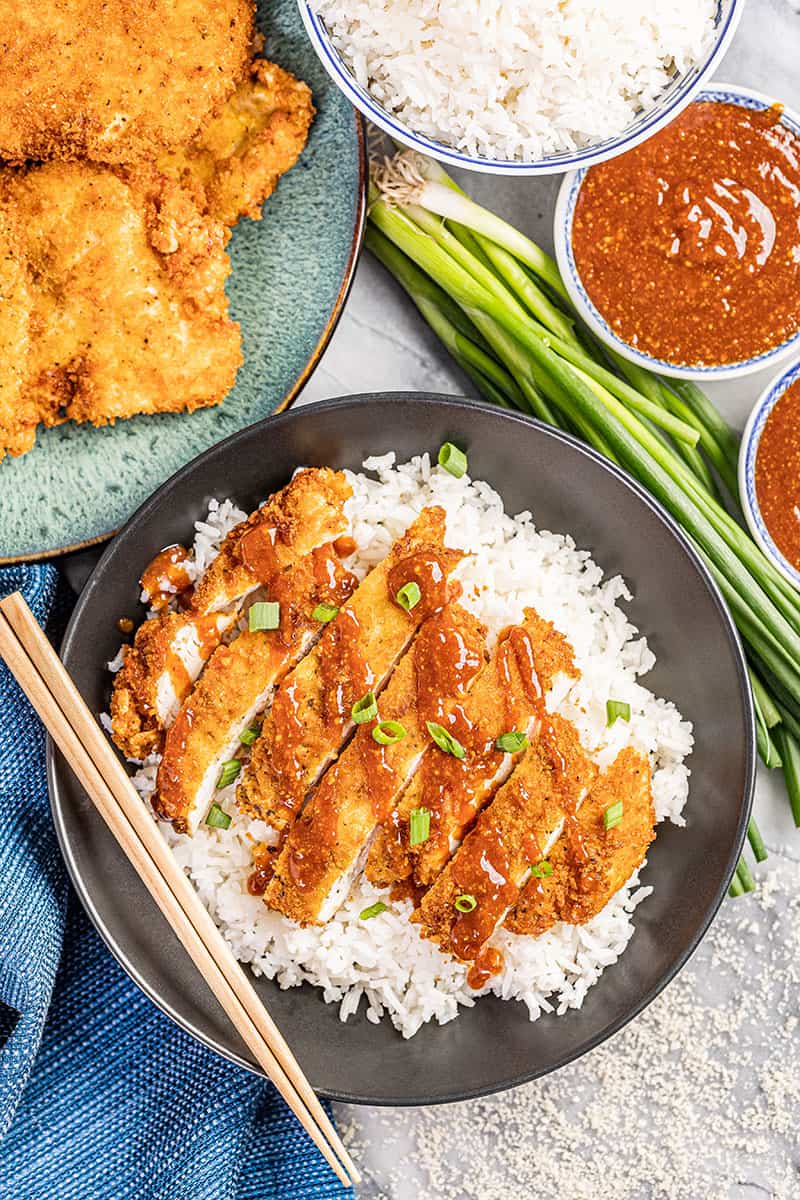 Overhead view of chicken katsu in a bowl with rice.