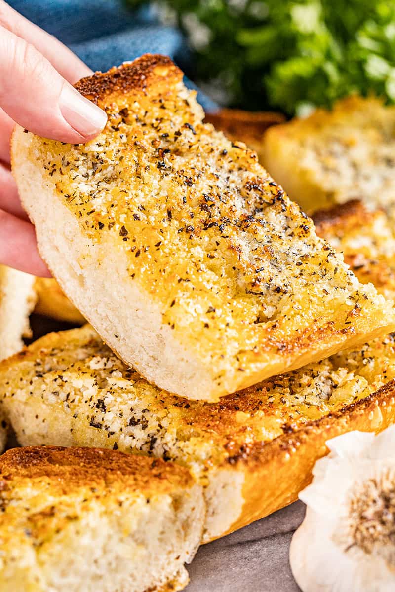 Close up view of a slice of garlic bread.