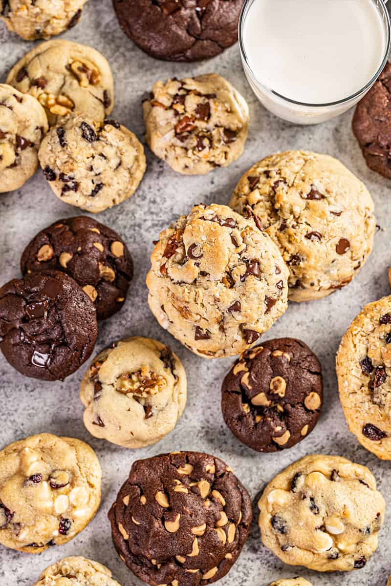 Overhead view of bakery style cookies with a glass of milk.