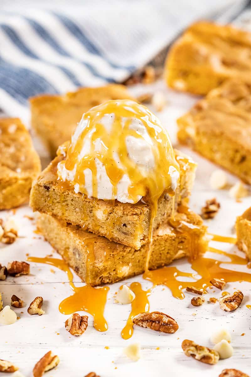 A stack of blondies with a scoop of vanilla ice cream on top.