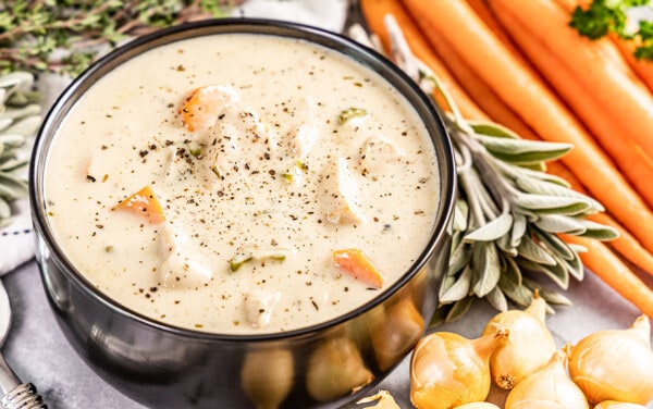 A black bowl filled with creamy chicken soup.
