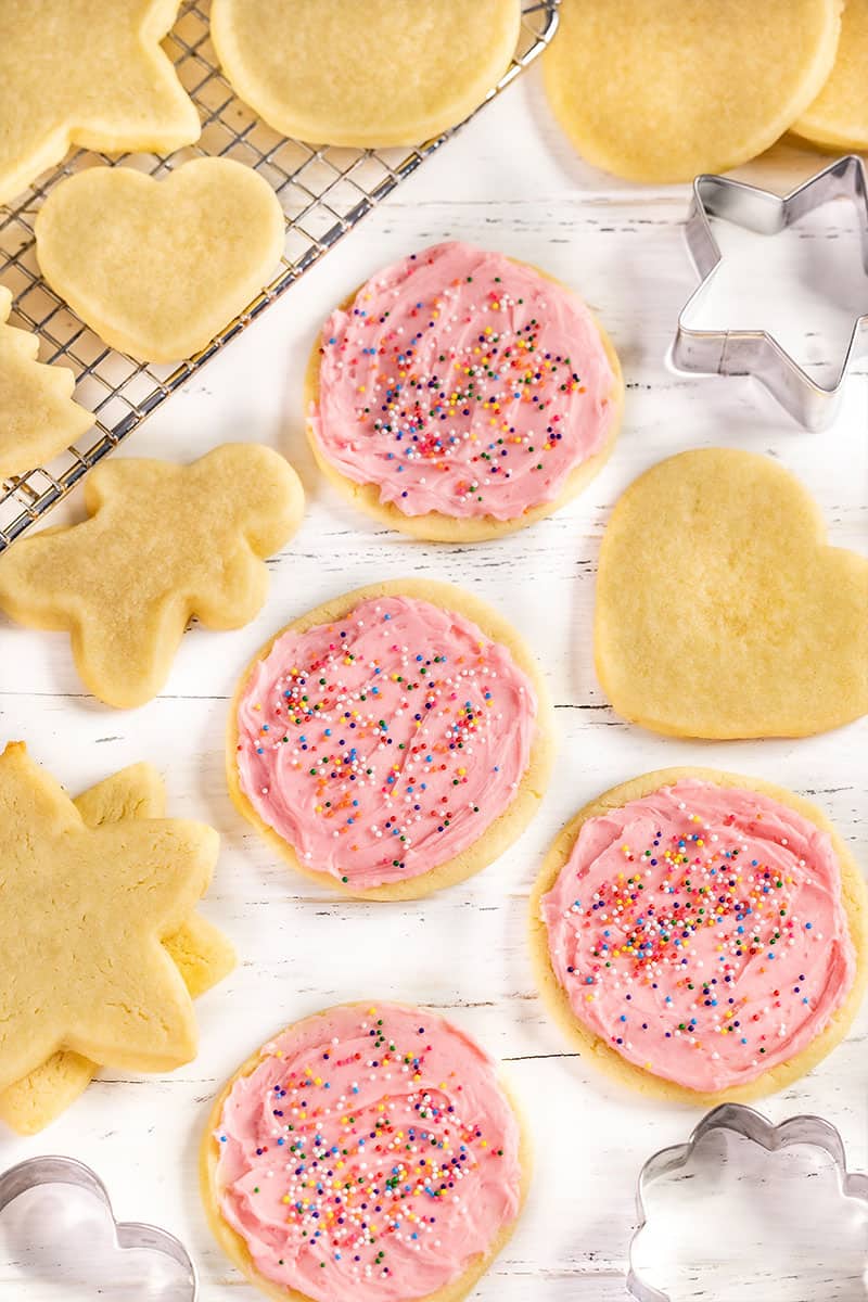 Overhead view of frosted and not frosted sugar cookies on a counter.