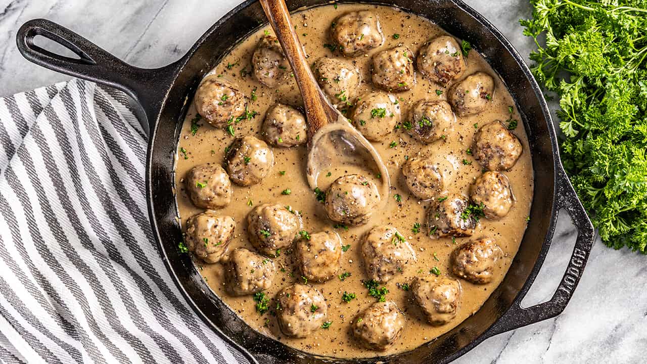Overhead view of Swedish meatballs in a cast iron pan.