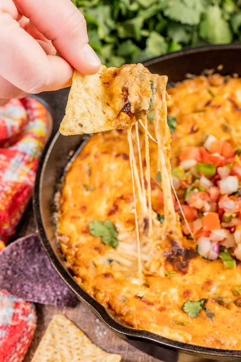 A chip dipped in cheesy skillet taco dip.