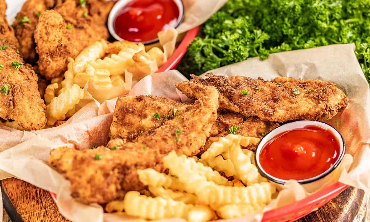 Chicken fingers and fries in a serving basket.