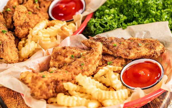 Chicken fingers and fries in a serving basket.