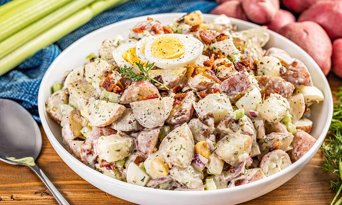 Large white serving bowl filled with creamy potato salad.