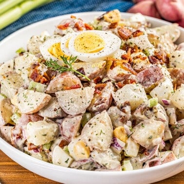 Large white serving bowl filled with creamy potato salad.
