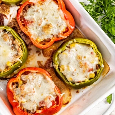 Overhead view of stuffed bell peppers in a white baking dish.