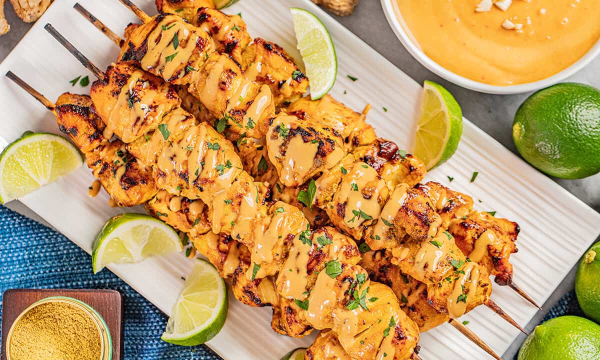 Overhead view of chicken satay with peanut dipping sauce.