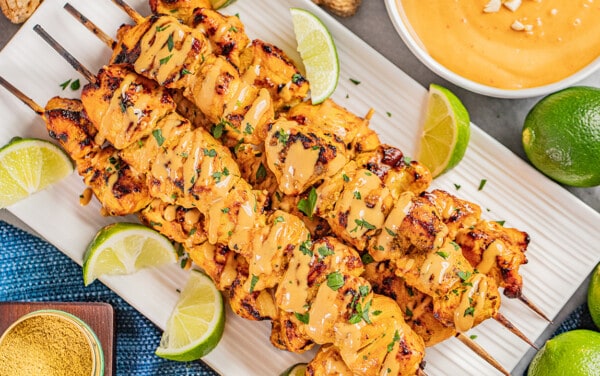 Overhead view of chicken satay with peanut dipping sauce.