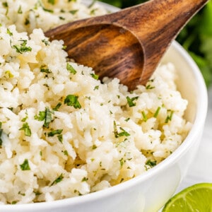 Close up view of cilantro lime rice with a wooden spoon.