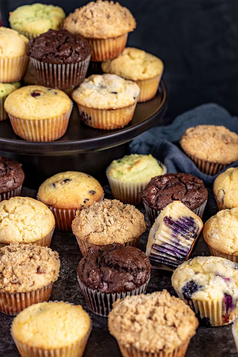 A variety of different flavored muffins on a countertop.