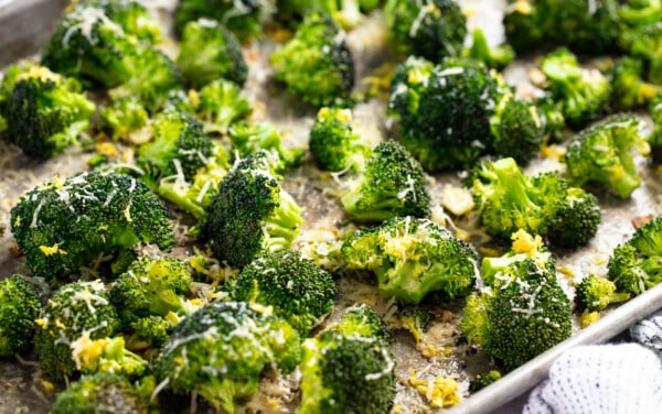 Close up view of roasted broccoli on a baking sheet.