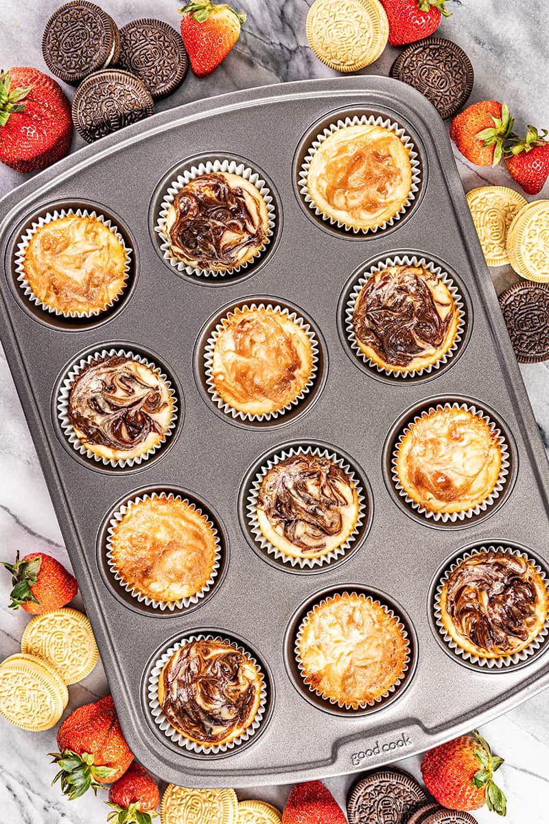 Overhead view of cheesecake cupcakes in a cupcake pan.