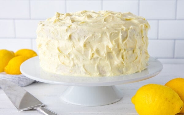 A whole lemon cake on a cake stand.