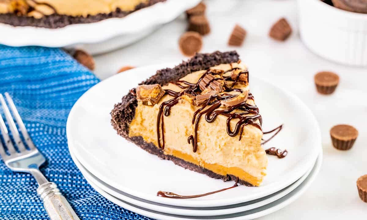A slice of peanut butter pie on a stack of dessert plates.