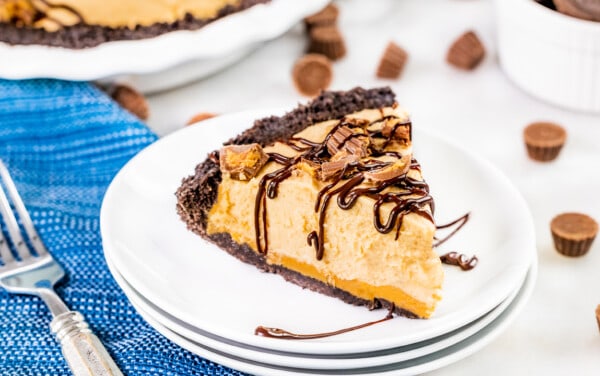 A slice of peanut butter pie on a stack of dessert plates.