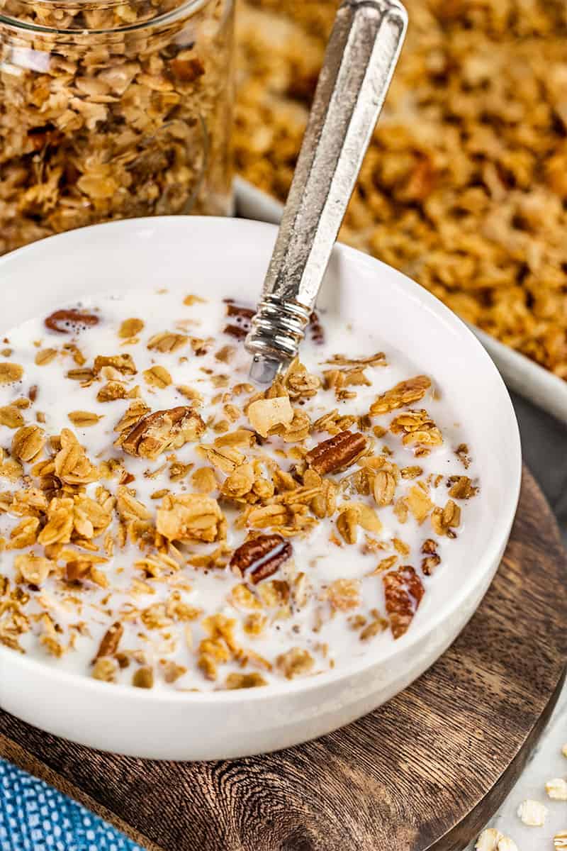 Homemade granola in a bowl with milk and a spoon.