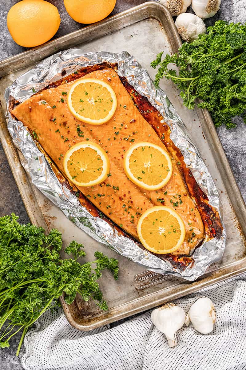 Overhead view of a salmon filet with orange slices on top.