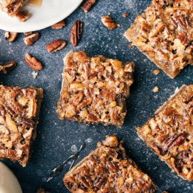 Individual servings of pecan bars scattered out over a black granite counter.