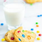 M&M cookies next to a glass of milk.