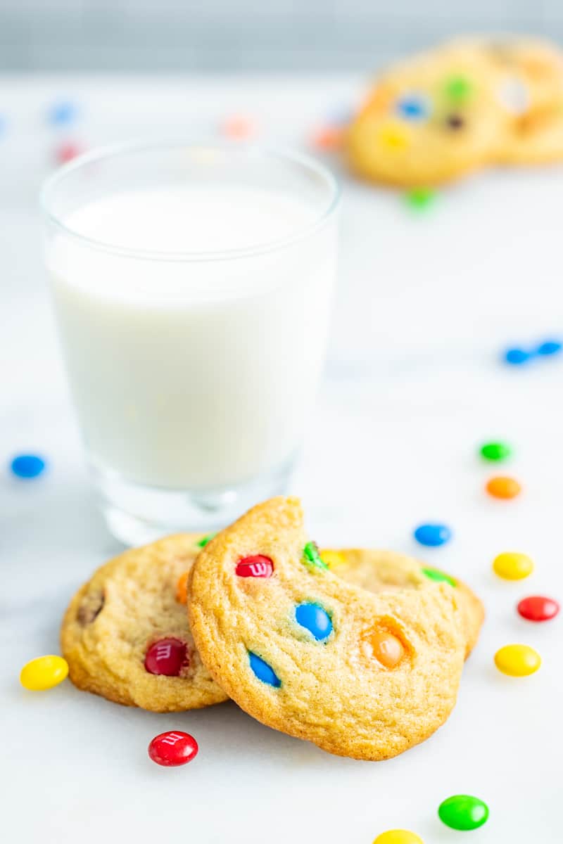 M&M cookies next to a glass of milk.