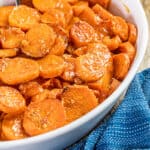 A spoon dipped into a baking dish filled with candied yams.