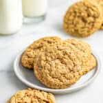Chewy oatmeal cookies on a plate with a half-eaten cookie.