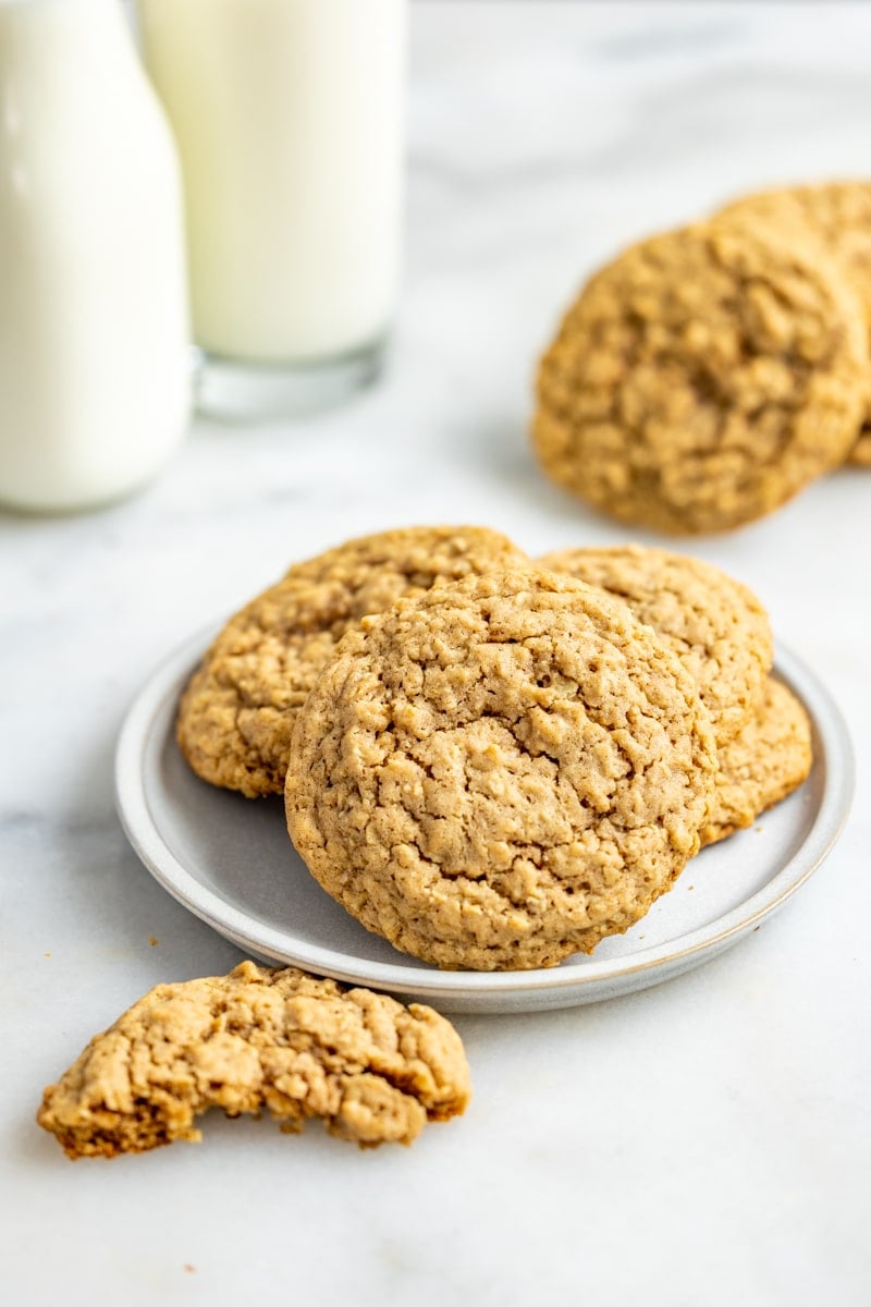 Chewy oatmeal cookies on a plate with a cookie half eaten.