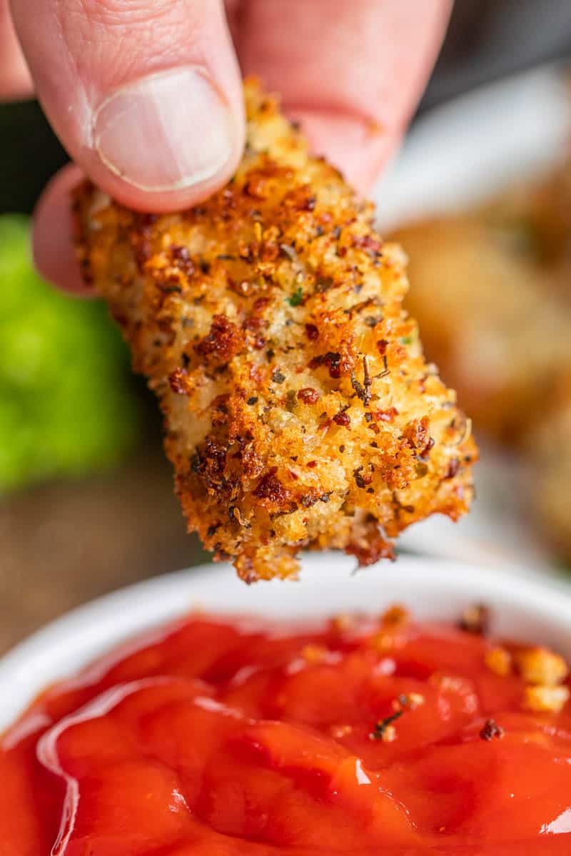 A hand holding a homemade chicken nugget.