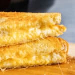 Close up view of grilled cheese sandwiches stacked on top of each other.