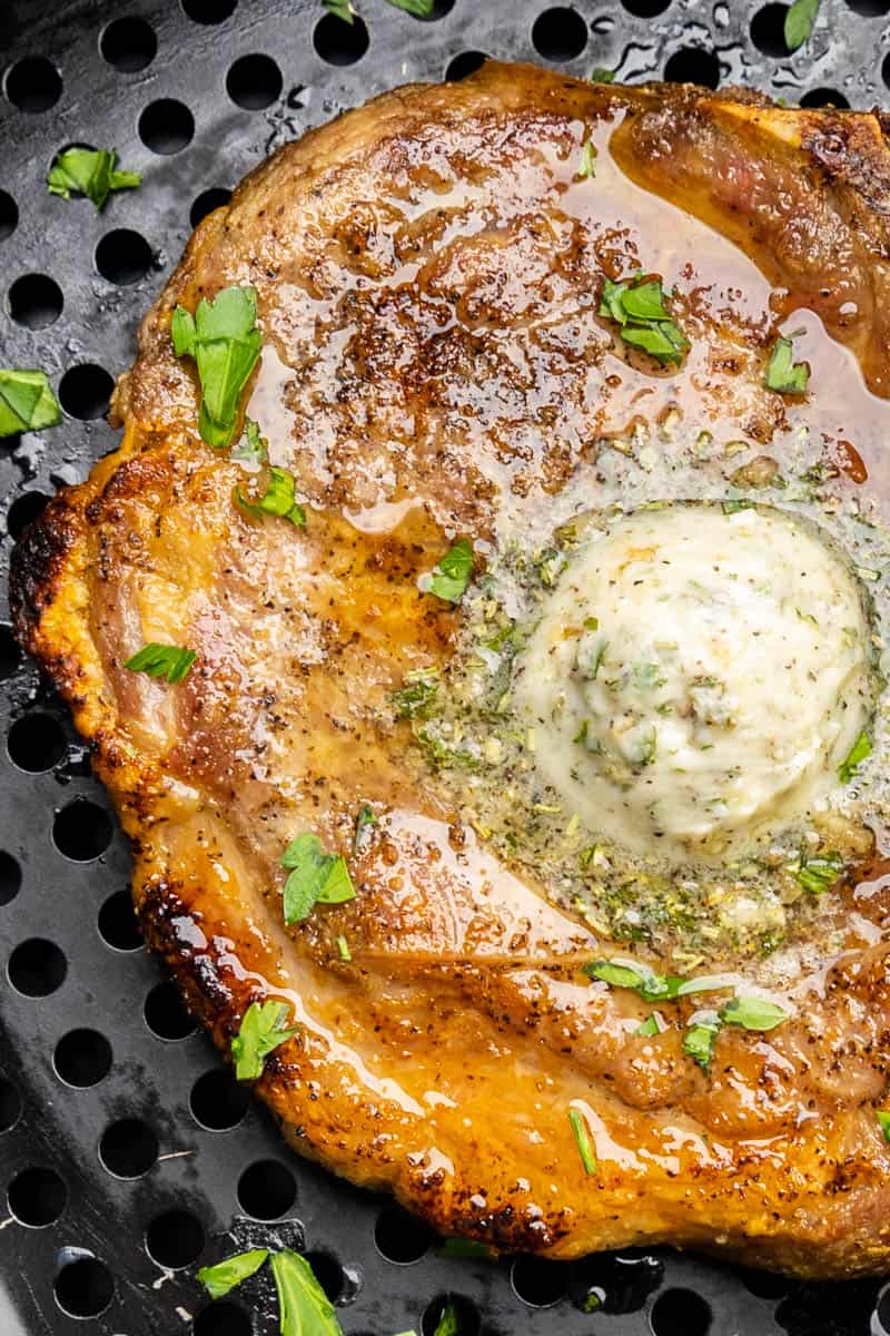 Overhead close up view of pork chop in an air fryer.