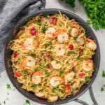 Overhead view of angel hair pasta with shrimp in a skillet.