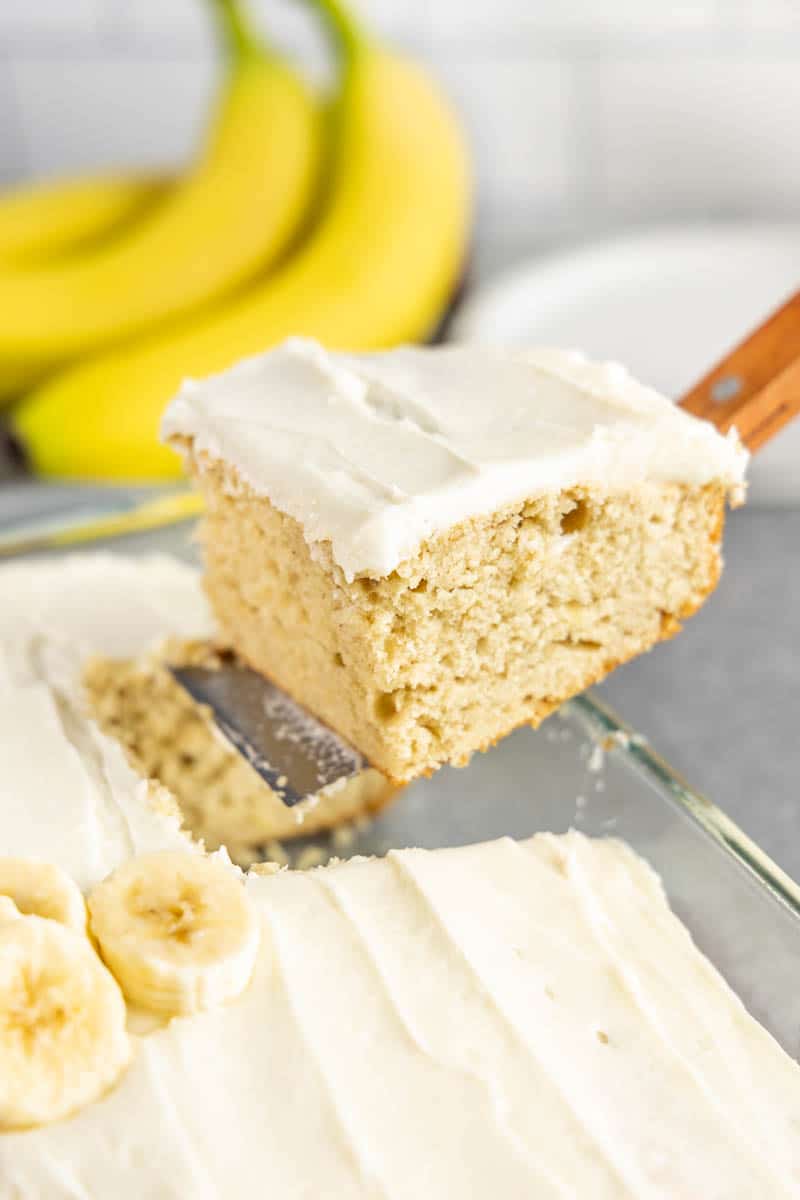 Holding up a slice of banana cake on a spatula.