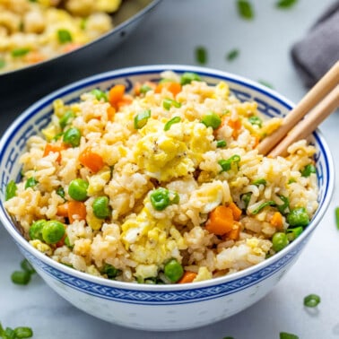 Takeout fried rice in a bowl with chopsticks.