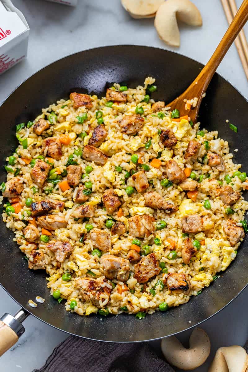 Overhead view looking into a wok of pork fried rice.