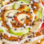 Close up view of apple nachos with mini chocolate chips and caramel.
