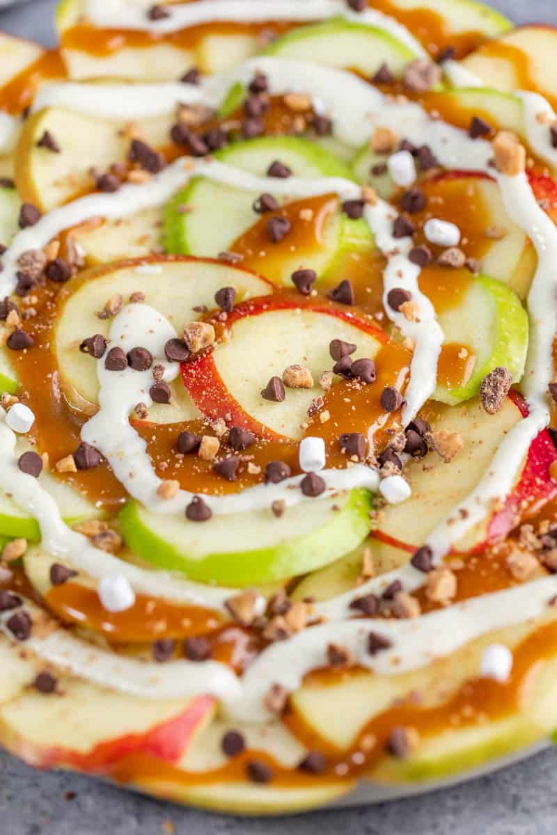 Close up view of apple nachos with mini chocolate chips and caramel.