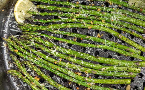 Close up overhead view of asparagus in an air fryer.