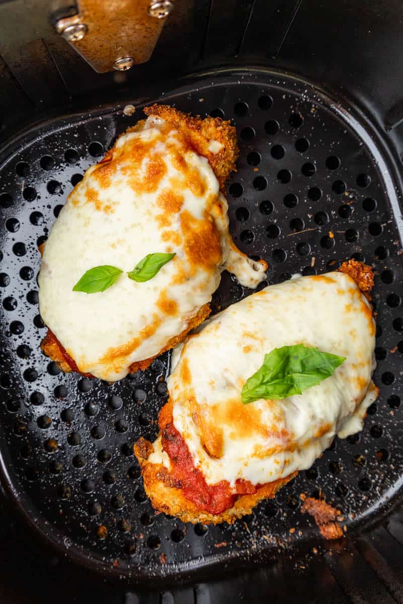 Chicken Parmesan in an air fryer basket.