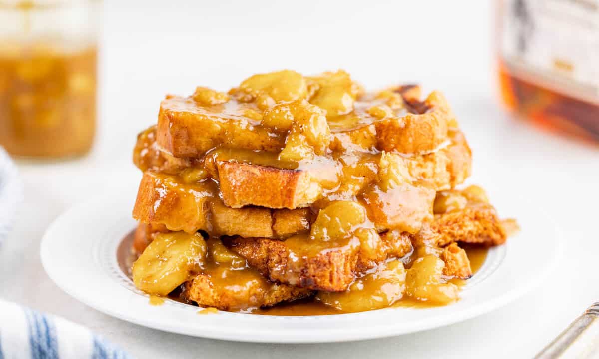 Bananas foster French toast piled on a white plate.