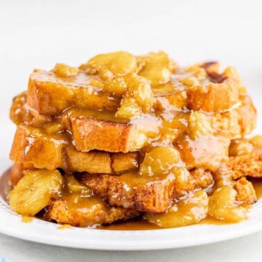 Bananas foster French toast piled on a white plate.