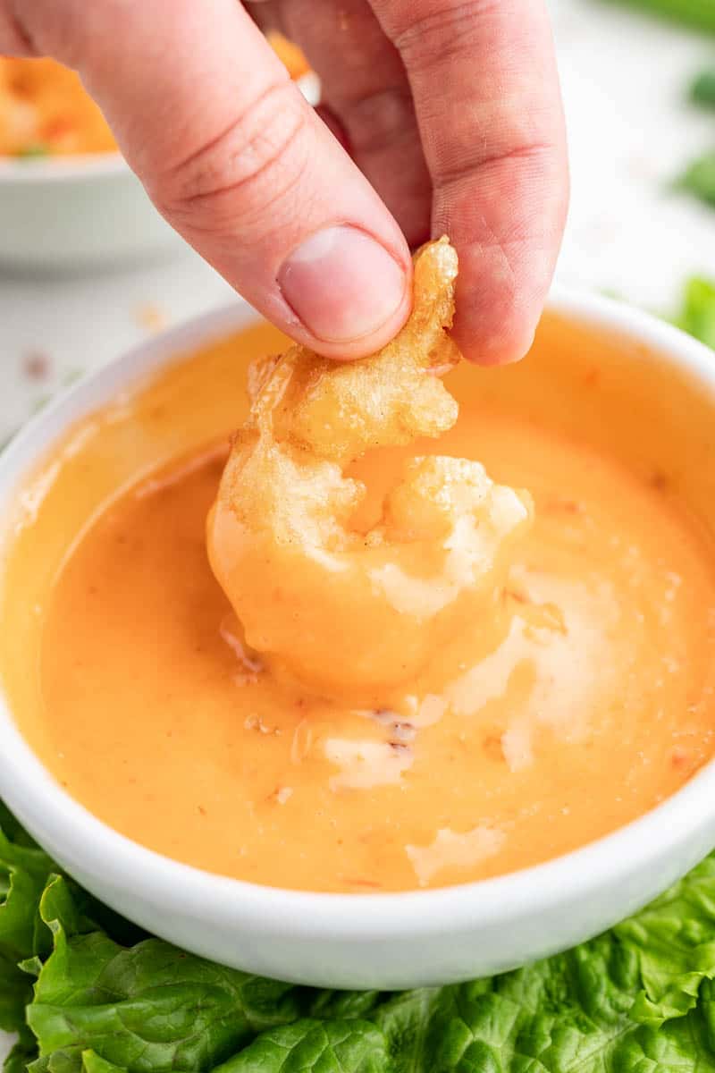 Dip a piece of shrimp into a bowl of Bang Bang Sauce.